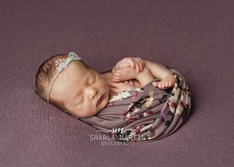 newborn girl wrapped in purple flower wrap austin