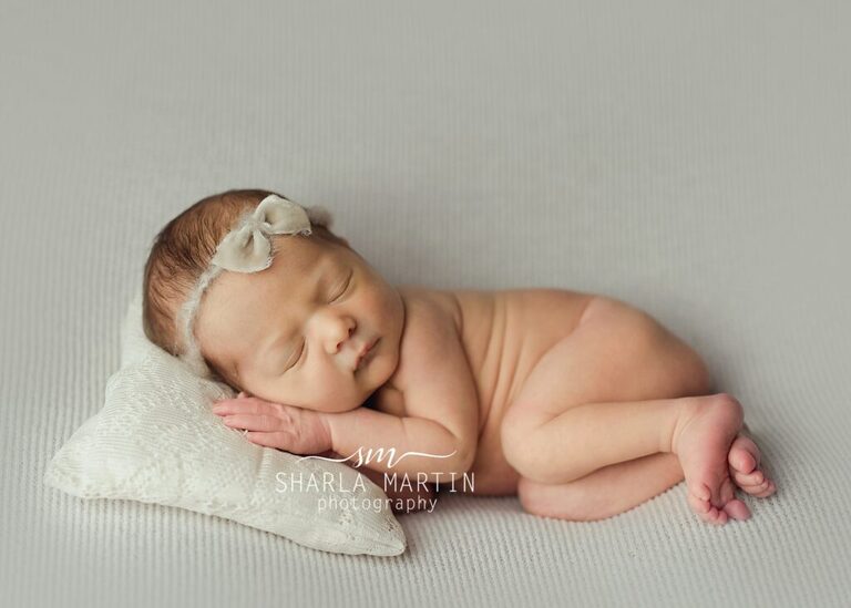 newborn baby girl posed on pillow