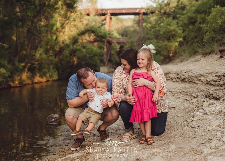 baby boy with family photo session by creek in cedar park tx