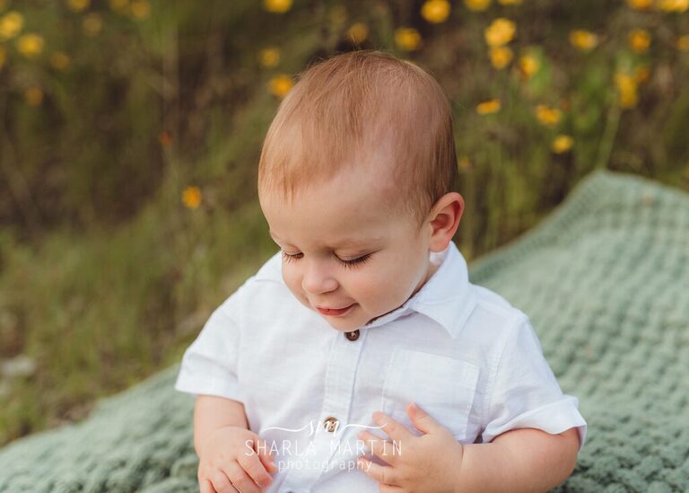 one year photo shoot with baby boy looking down