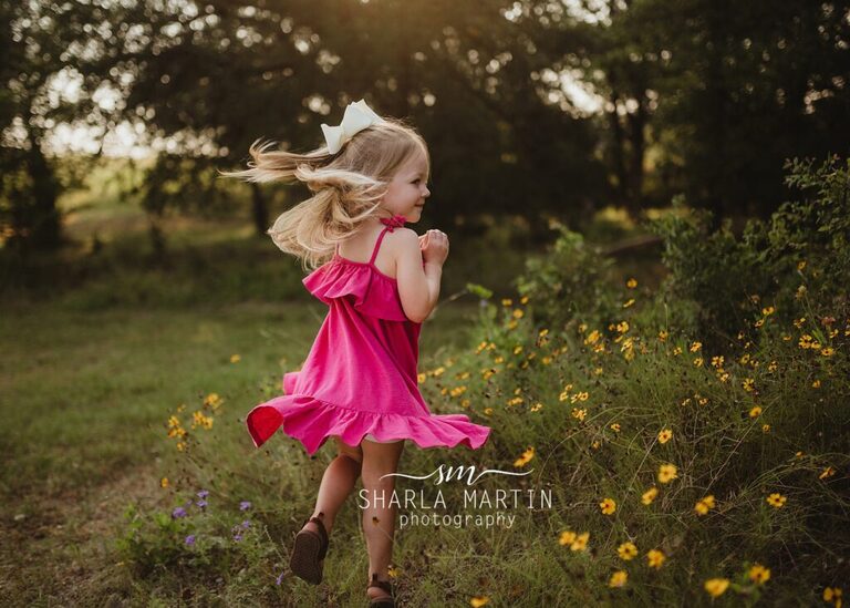 little girl spinning in flowers