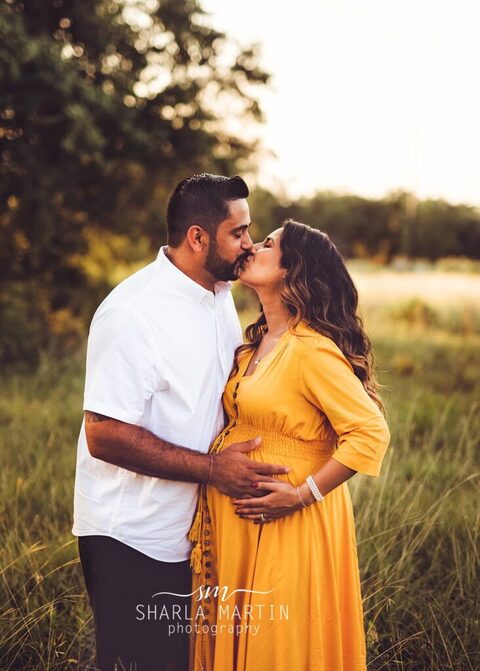 maternity couple kissing in field austin