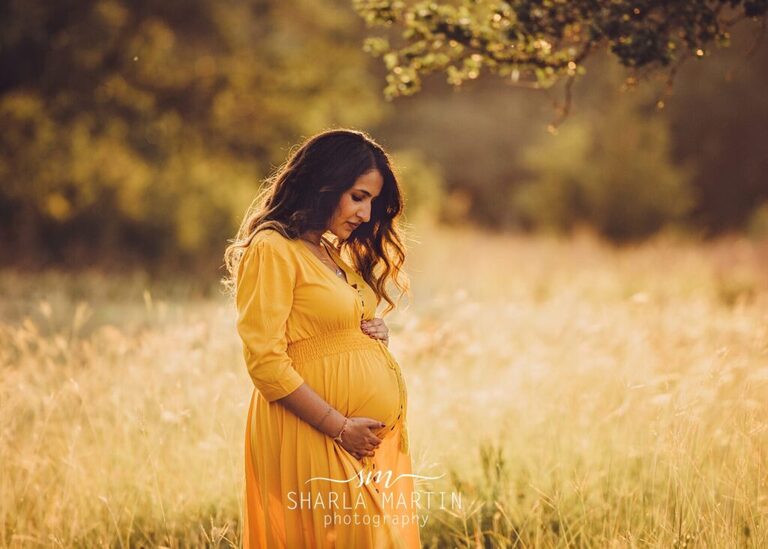 pregnant mama in field with sun lighting her hair