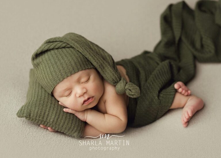 newborn baby boy sleeping with pillow and sleepy hat for photo shoot
