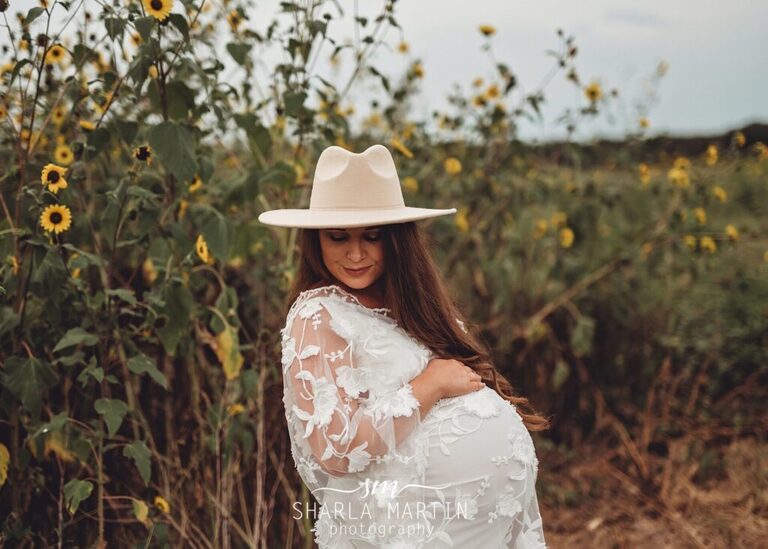 pregnant mother in sunflower field for maternity photos in Liberty Hill Texas
