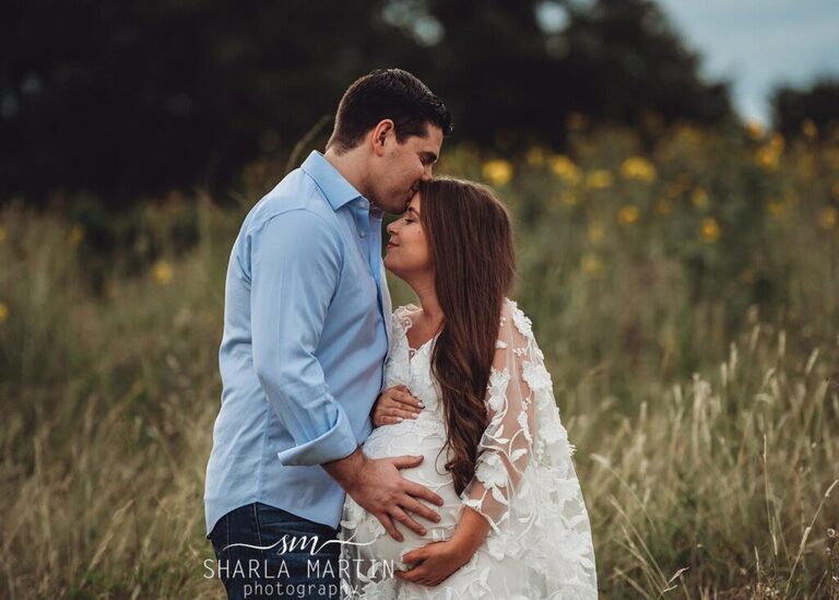 couple kissing in sunflower field for maternity photo session in Austin