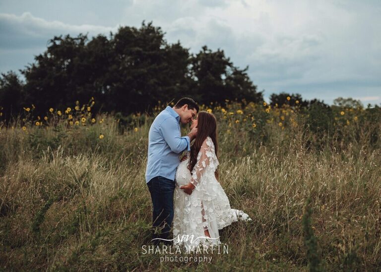 couple kissing in sunflower field for maternity photo session in Cedar Park TX