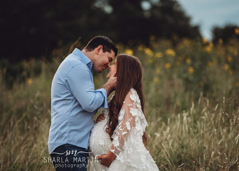 couple kissing in sunflower field for maternity photo shoot in Cedar Park TX
